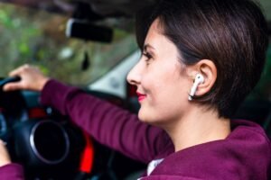 Conductrice au volant portant une oreillette sans fil dans l'oreille, dispositif interdit pendant la conduite