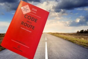 Ouvrage rouge du Code de la route édition 2026 posé sur une route de campagne