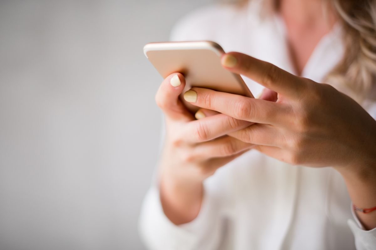Femme effectuant une démarche de contestation d'amende en ligne sur son smartphone