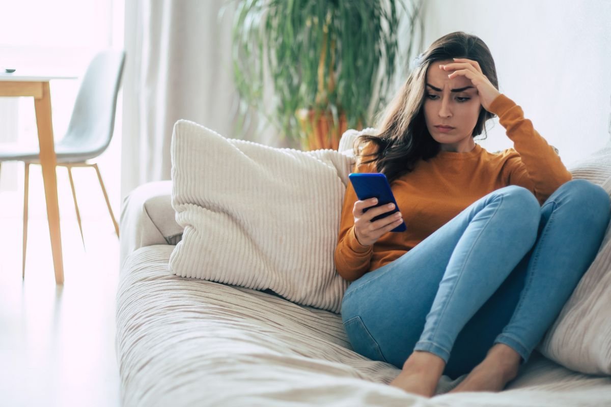 Femme préoccupée consultant son téléphone en attendant la réponse à sa contestation d'amende