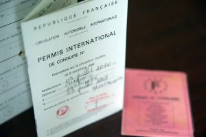 Permis international de conduire français ouvert à côté d'un permis national, document pour conduire à l'étranger