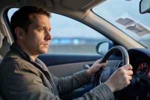 En cas de gros excès de vitesse, la suspension de permis est-elle automatique ? Conducteur en réflexion au volant d'une voiture, concept suspension permis vitesse